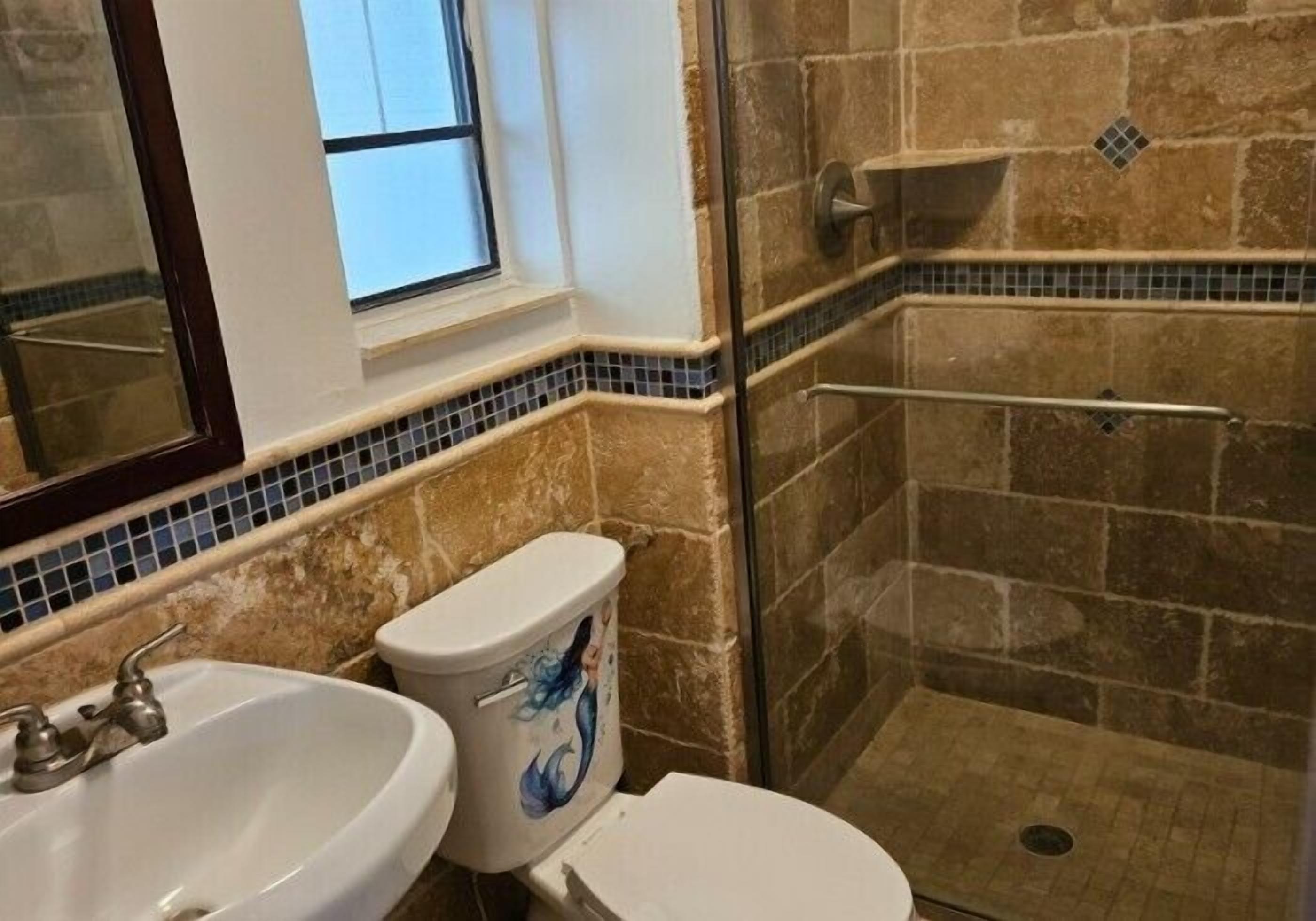 Ein Badezimmer mit Waschbecken, Toilette und Duschbereich.