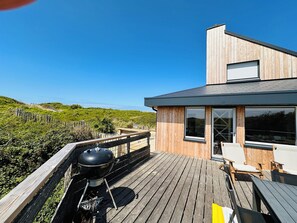A modern wooden deck with a barbecue grill, overlooking a lush landscape. - Les Eléments - Quiet, dunes and sandy beach within walking distance - 6 people (Quend)
