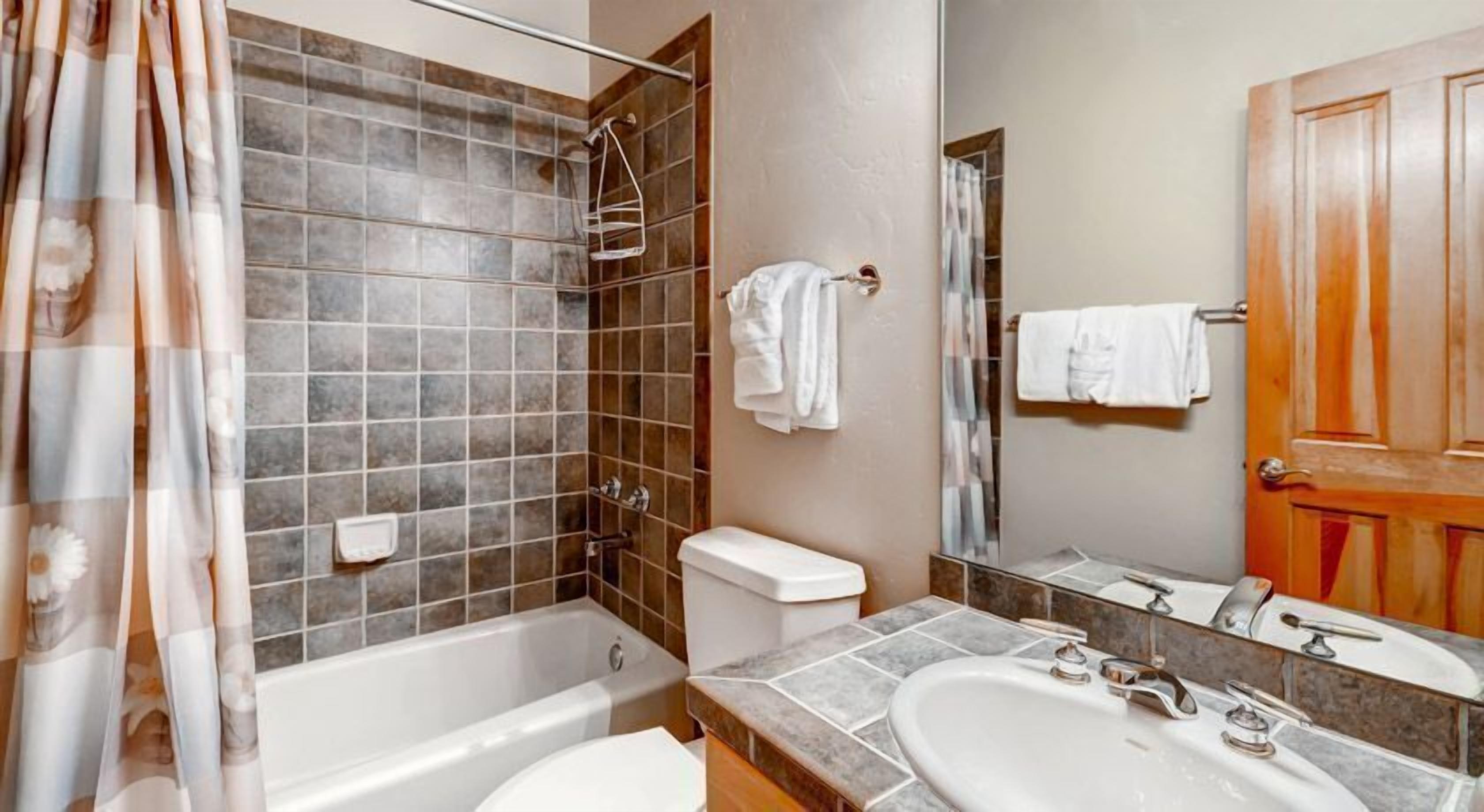 A bathroom with a bathtub, toilet, and sink.