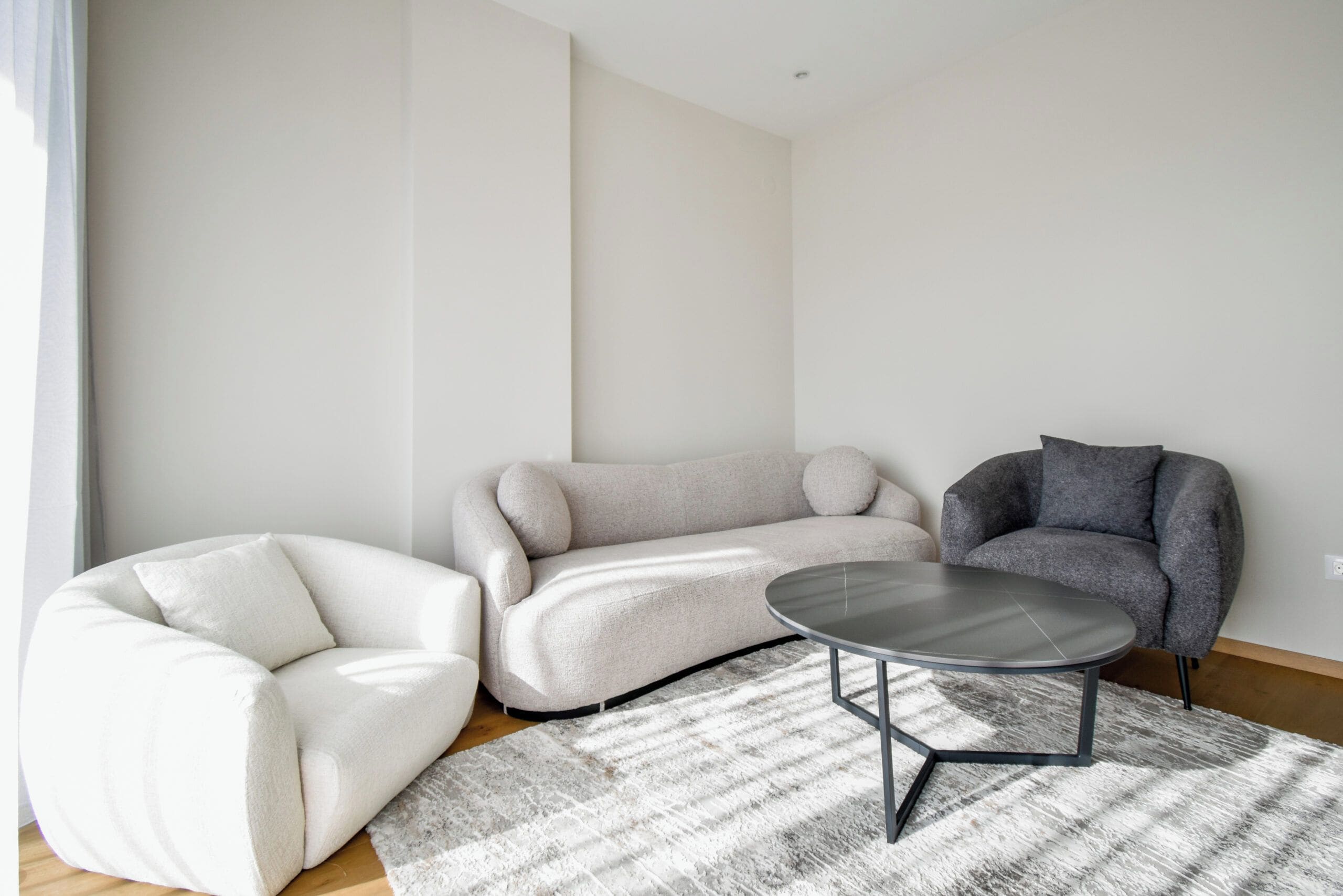 Een moderne woonkamer met een modulaire bank, een fauteuil en een salontafel.