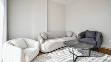 Een moderne woonkamer met een modulaire bank, een fauteuil en een salontafel.