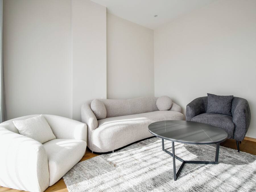 Een moderne woonkamer met een modulaire bank, een fauteuil en een salontafel.
