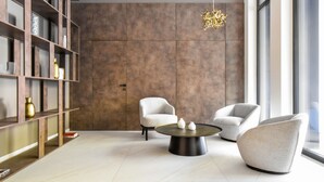 A modern living room with a large bookshelf, two armchairs, a coffee table, and a hanging light fixture. -  Hayashi Residence (Sofia)
