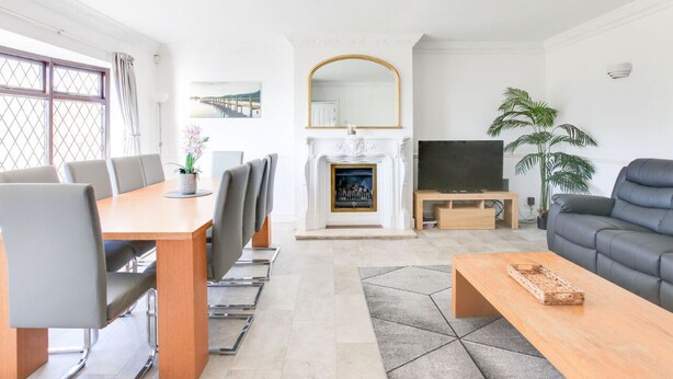 Un salon moderne avec une cheminée, un téléviseur et un canapé.