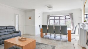 Un salon moderne comprenant un canapé, une table à manger, des chaises et une cheminée.