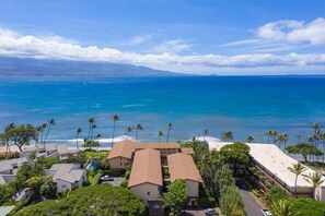 A coastal hotel with multiple buildings, a beach, and palm trees. - Hono Kai B4 Maui Ocean Views from all 3 walls! (Wailuku)