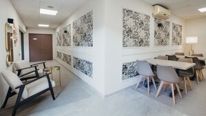 Ein Konferenzraum mit einem langen Tisch, Stühlen und einer Whiteboard-Wand.