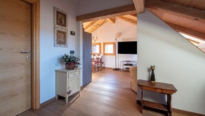 Un intérieur en bois comprenant un coin repas, un téléviseur et une petite table agrémentée d’un objet décoratif.