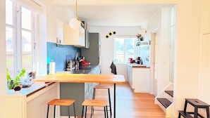 A modern kitchen with a central island, bar stools, and a view of the outside. - Great family house in CPH (Gentofte)