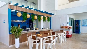 Zona de bar moderna amb un mostrador, seients i una planta en test.