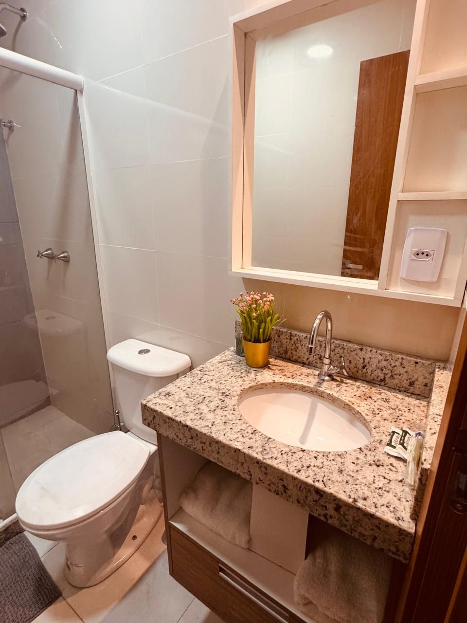 A bathroom with a toilet, sink, and shower.
