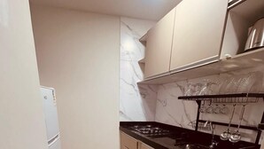 Eine Küche mit schwarzem Arbeitsplatz, weißen Schränken und einer Marmor-Spritzschutzwand.