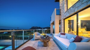 Uma área externa moderna para relaxamento, com sofá, cadeiras e mesa de centro.