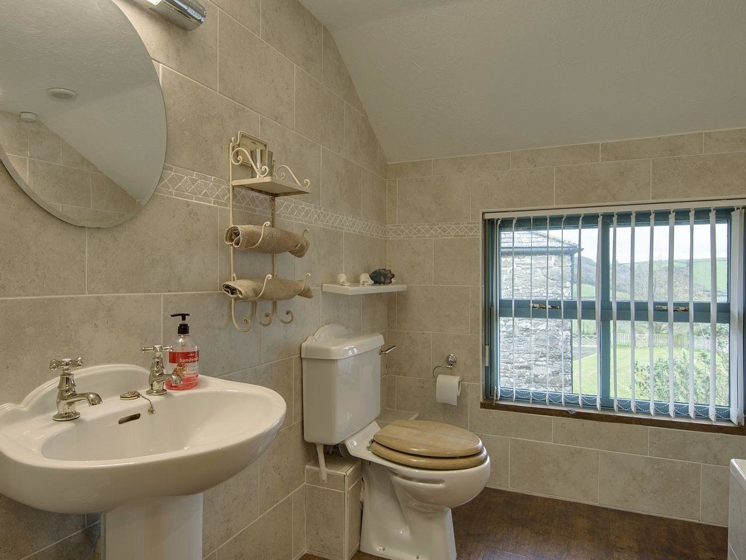 A bathroom with a sink, toilet, and window with bars.