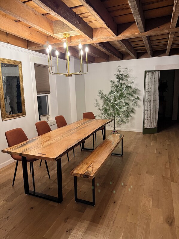 En matplats med ett långt träbord, bänkar och röda stolar.