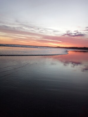 A beach with wet sand and gentle waves, a clear sky, and a sunset. - Doña Elsa Cabins (sleeps 5)  (Mar del Plata)