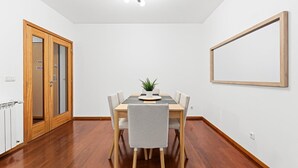 Un espace repas comprenant une table en bois, des chaises et un luminaire suspendu au plafond.