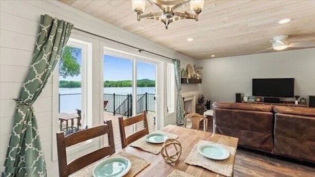 A dining area with a view of a balcony and a fireplace. - 3-bedroom waterfront cottage with unmatched views and dock on Tennessee River (Decatur)
