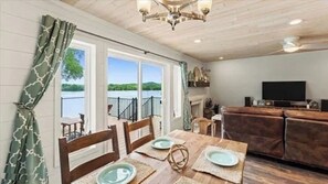 A dining area with a view of a balcony and a fireplace. - 3-bedroom waterfront cottage with unmatched views and dock on Tennessee River (Decatur)
