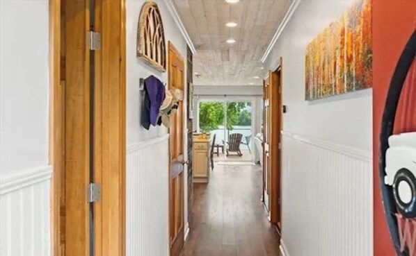 A hallway with wooden doors, a radiator, and a painting on the wall. - 3-bedroom waterfront cottage with unmatched views and dock on Tennessee River (Decatur)