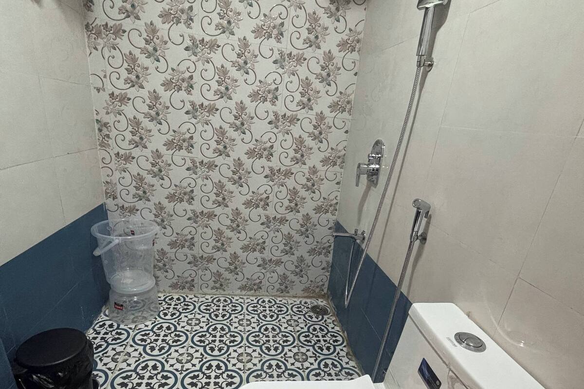 Een kleine badkamer met toilet, douche en wastafel.