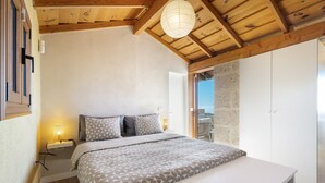 Un dormitorio con cama, mesita de noche, lámpara y armario.
