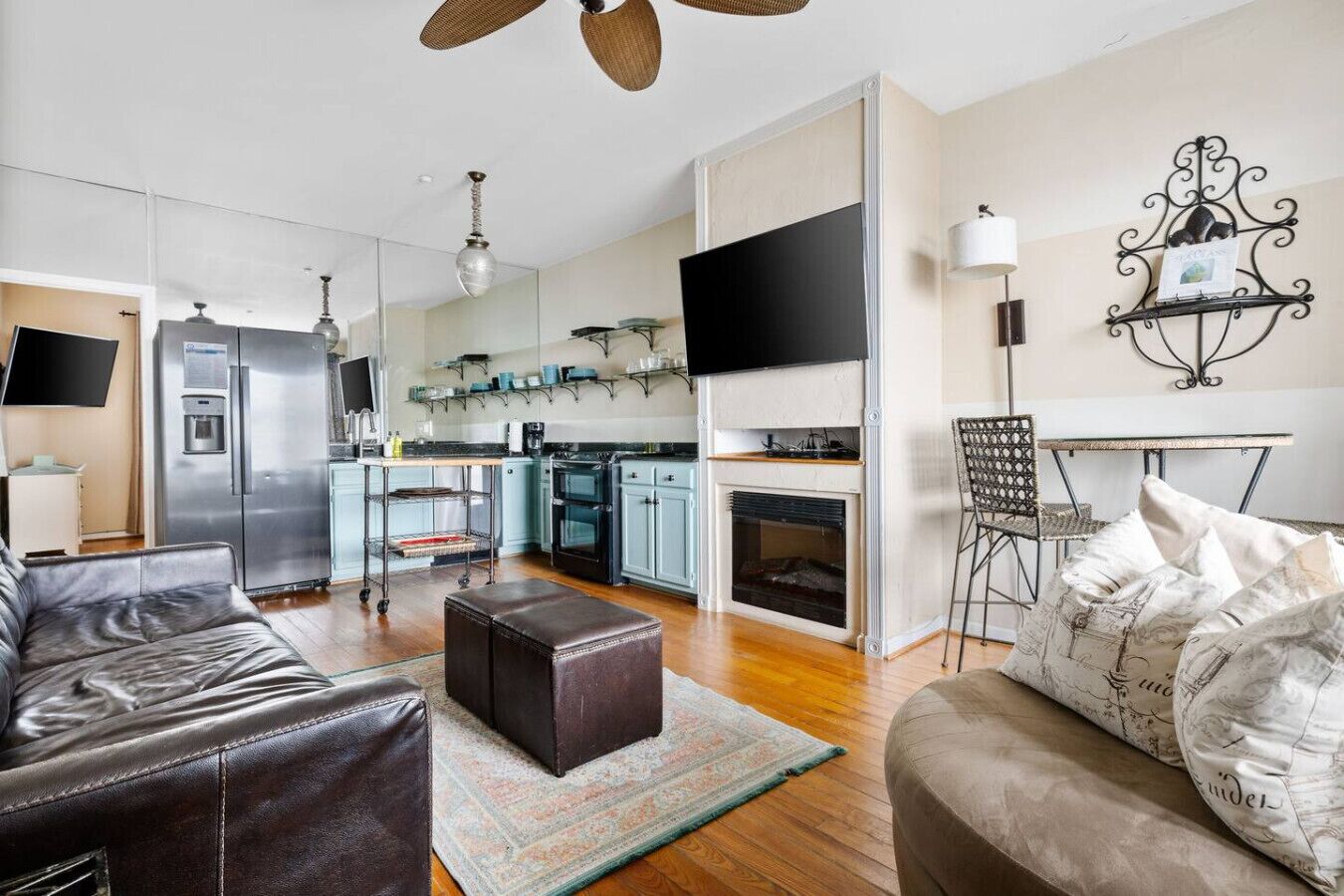 A modern living room with a leather sofa, ottoman, and a patterned rug.