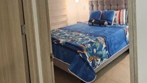 A bedroom with a bed, a headboard, and a bedside lamp. - Beautiful apartment with a spectacular view (Cali)