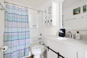 A bathroom with a white sink, a mirror, a toilet, and a shower curtain. - Cozy 2BR Getaway Minutes to Downtown - Dayton A (North Charleston)