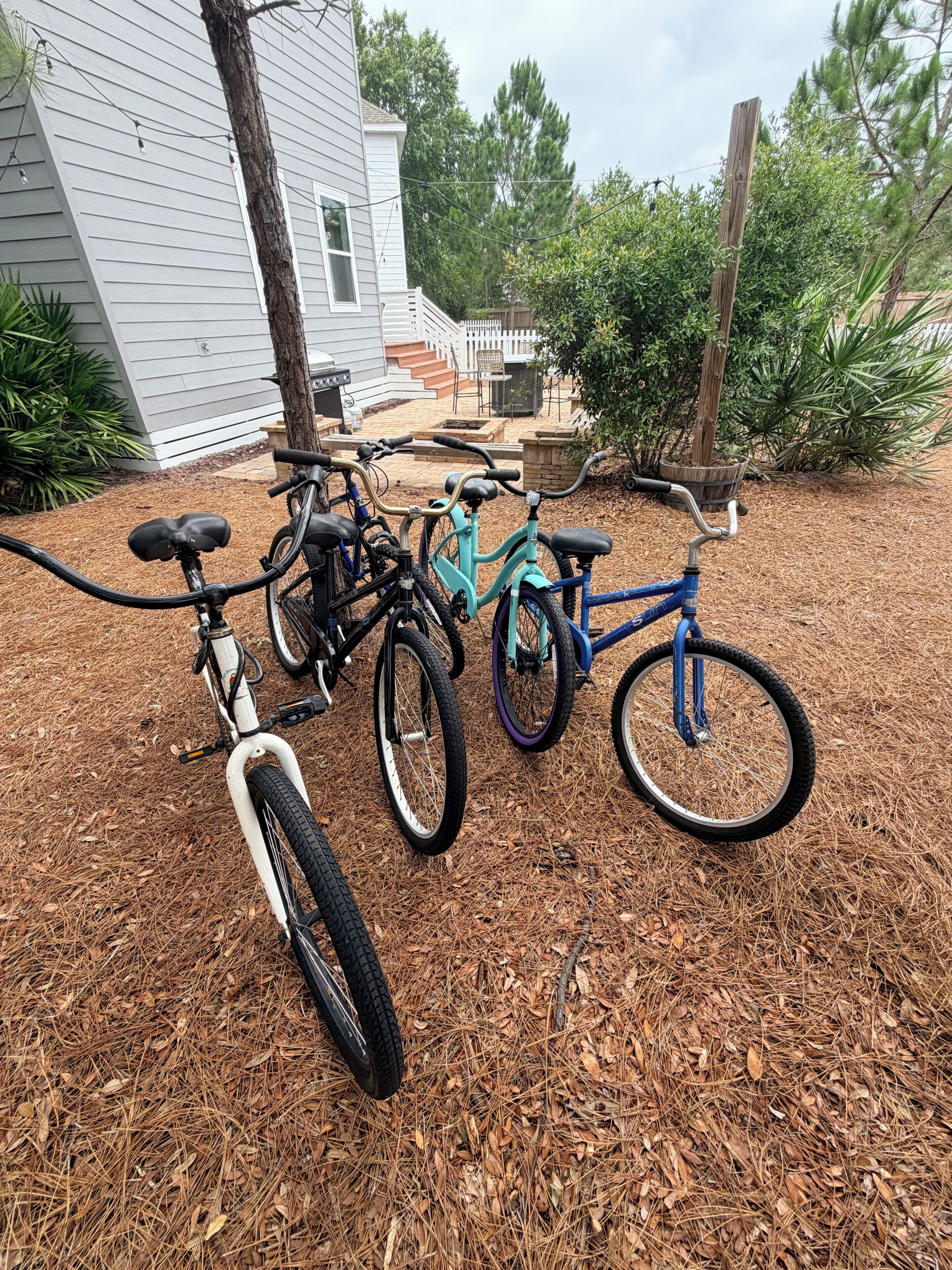 A bicycle parked on a wooden deck with a house in the background.