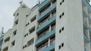A multi-story building with balconies and a gated entrance. - Amicable Corporate Apartment (Mumbai)