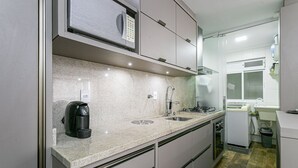 Una cucina moderna con piani di lavoro in granito, elettrodomestici in acciaio inossidabile e forno a incasso.
