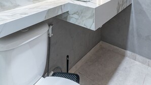 Une salle de bain moderne avec un meuble-lavabo en marbre, un grand miroir et des toilettes.