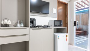 Eine moderne Küche mit Flachbildfernseher, Kaffeemaschine, Mikrowelle und Kühlschrank.