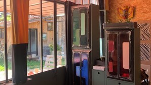 Ein Zimmer mit großen Fenstern, einem Holzkleiderschrank, einer Vitrine und einem dekorativen Gegenstand an der Wand.