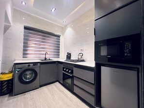 Apartamento família, sacada, vista para a cidade | Cozinha privada | Geladeira, micro-ondas, fogão, cooktop