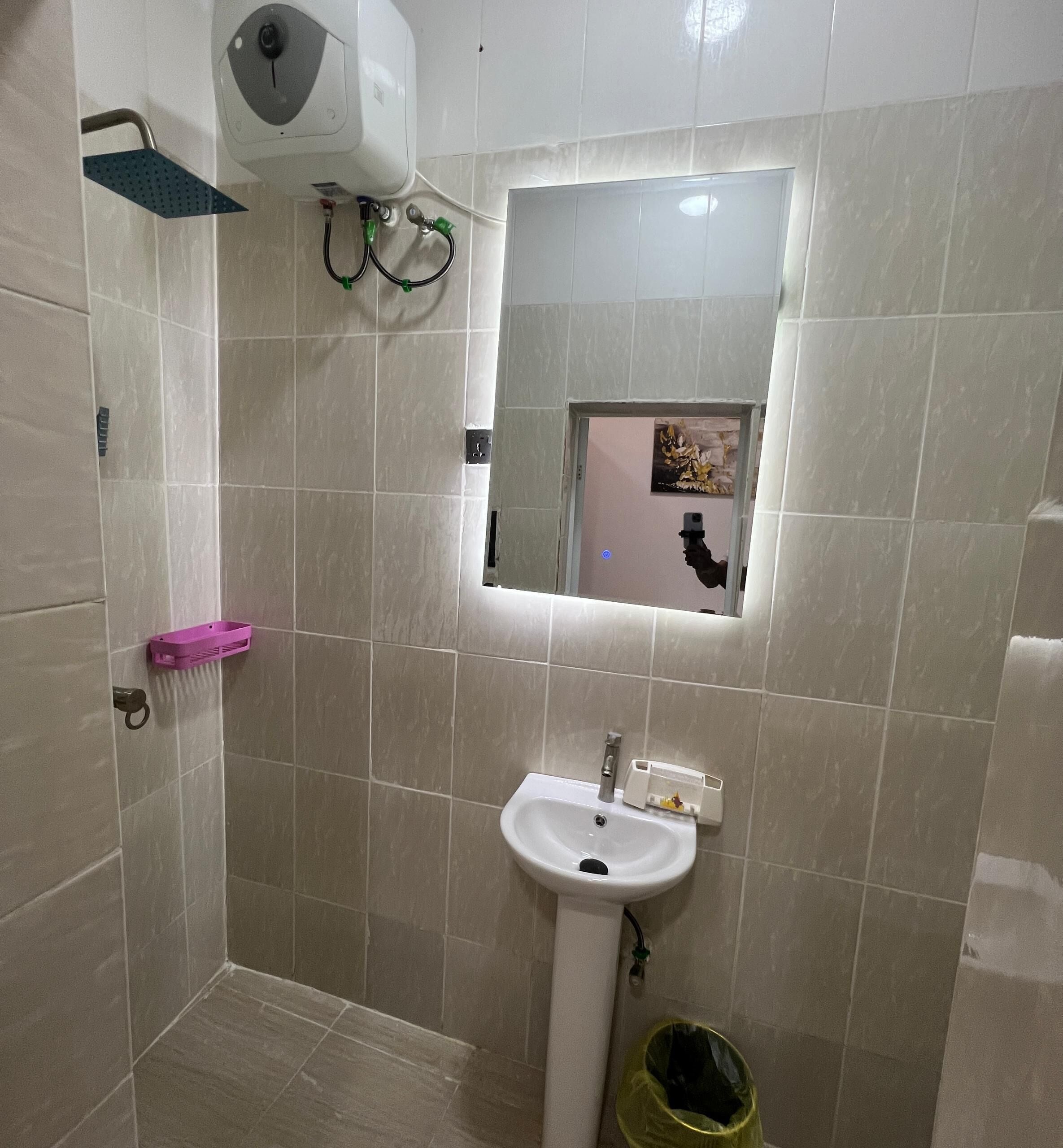 A bathroom with a shower, a sink, and a small window.
