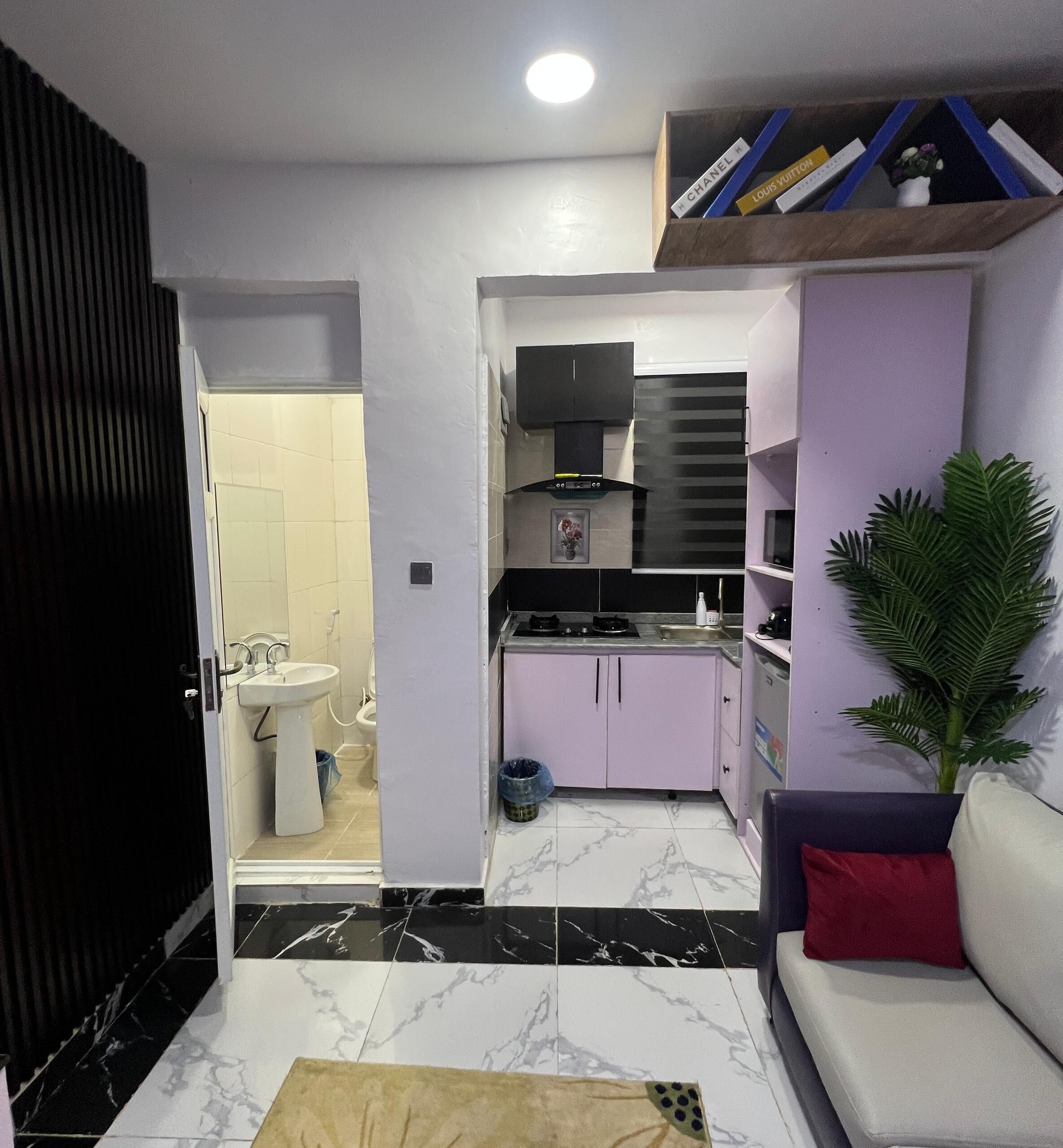 A compact living space with a kitchenette, a bathroom, and a seating area.