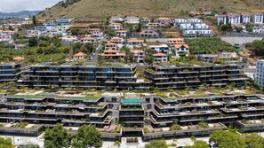 A modern residential complex with multiple high-rise buildings, rooftop gardens, and a central swimming pool. - Lyra Luxury Savoy Monumentalis by LovelyStay (Funchal)