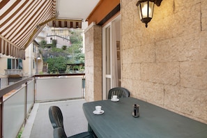 A balcony with a table, chairs, and a lantern. - Apartment 'Zaffiro  with Garage' with Private Terrace, Wi-Fi and Air Conditioning (Rapallo)
