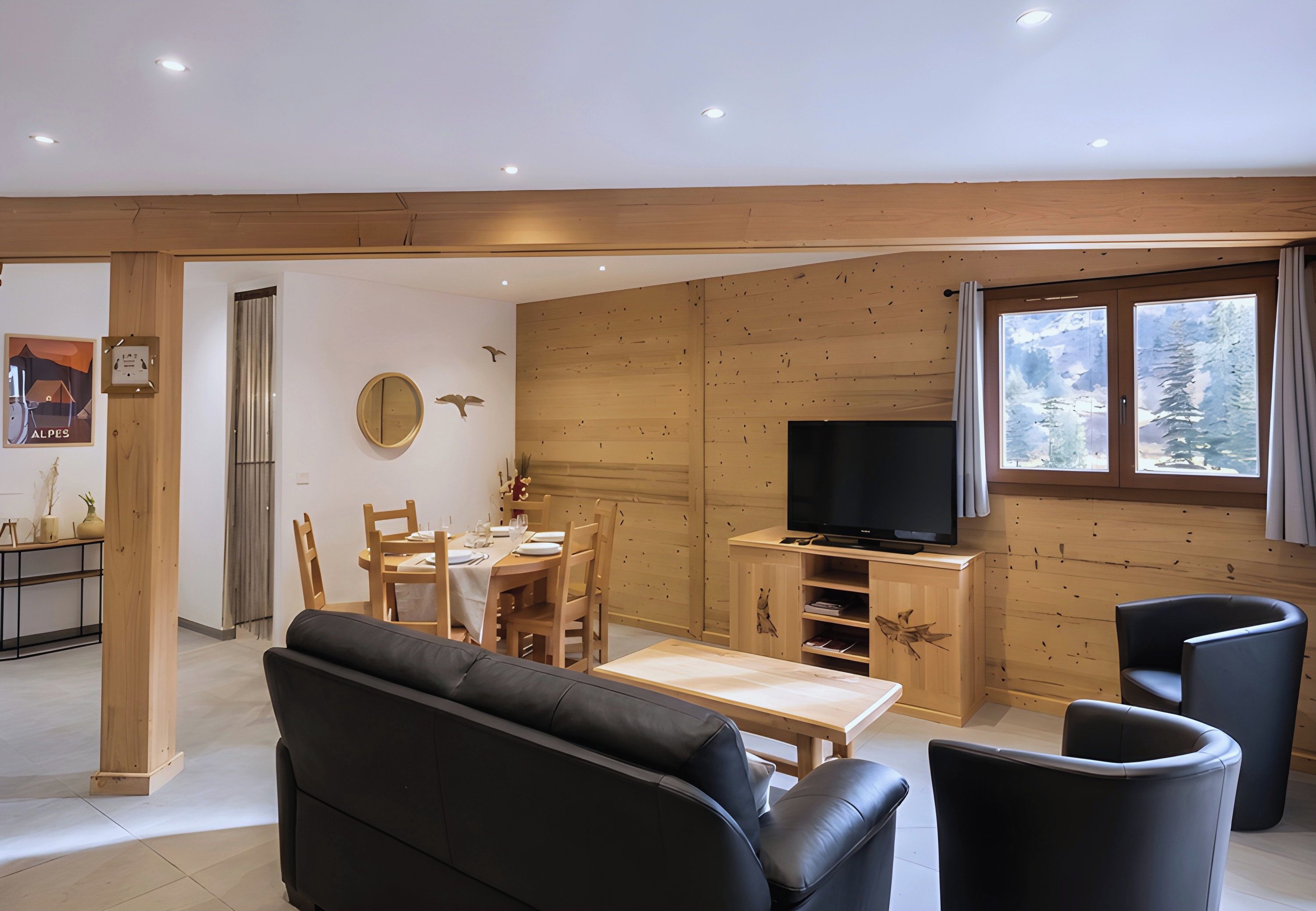 A modern living room with a black sofa, wooden dining table, and chairs, a TV, and a large window with a view of trees.