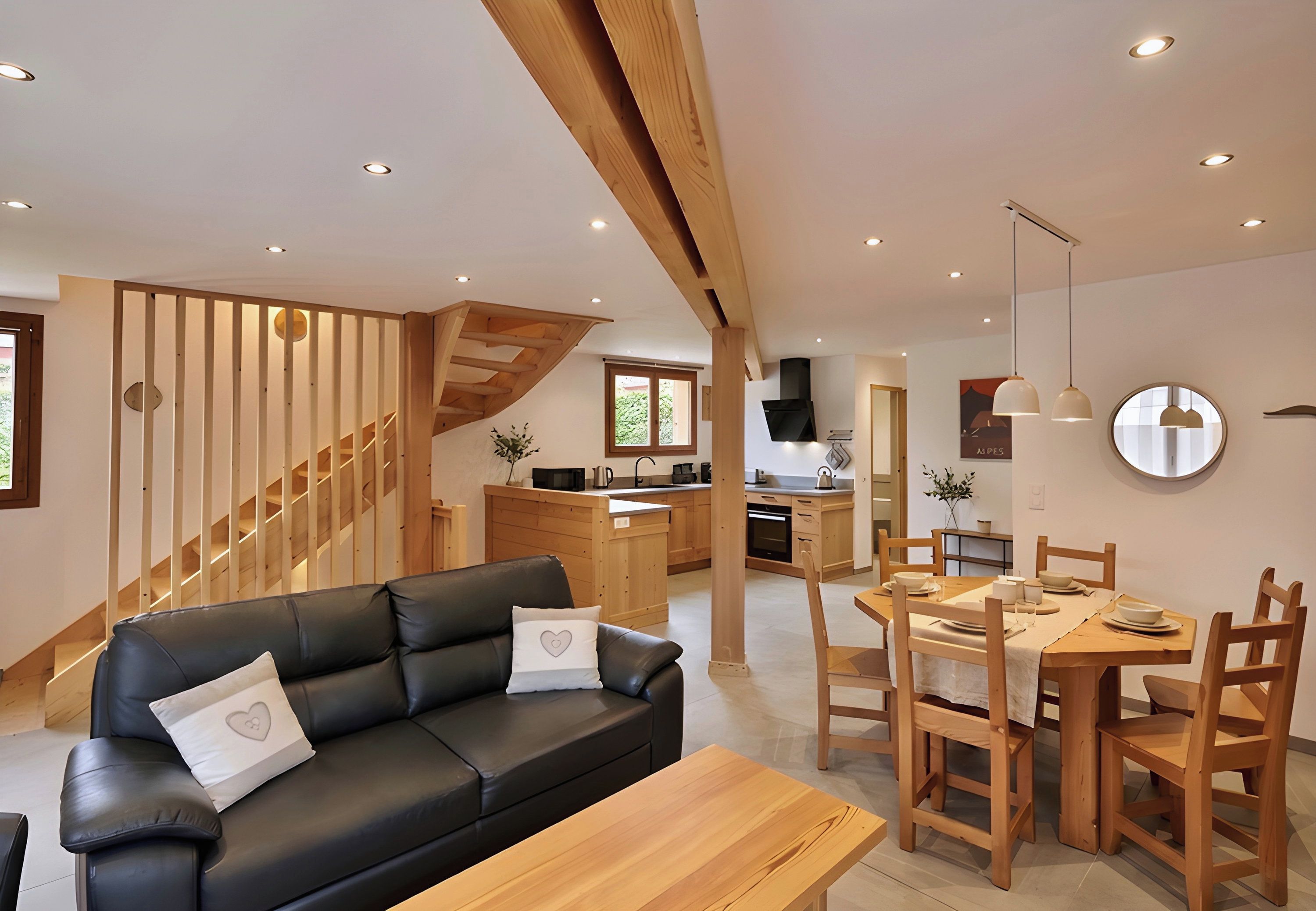 Un intérieur moderne avec un canapé en cuir noir, une table à manger en bois et un escalier doté de rampes en bois.
