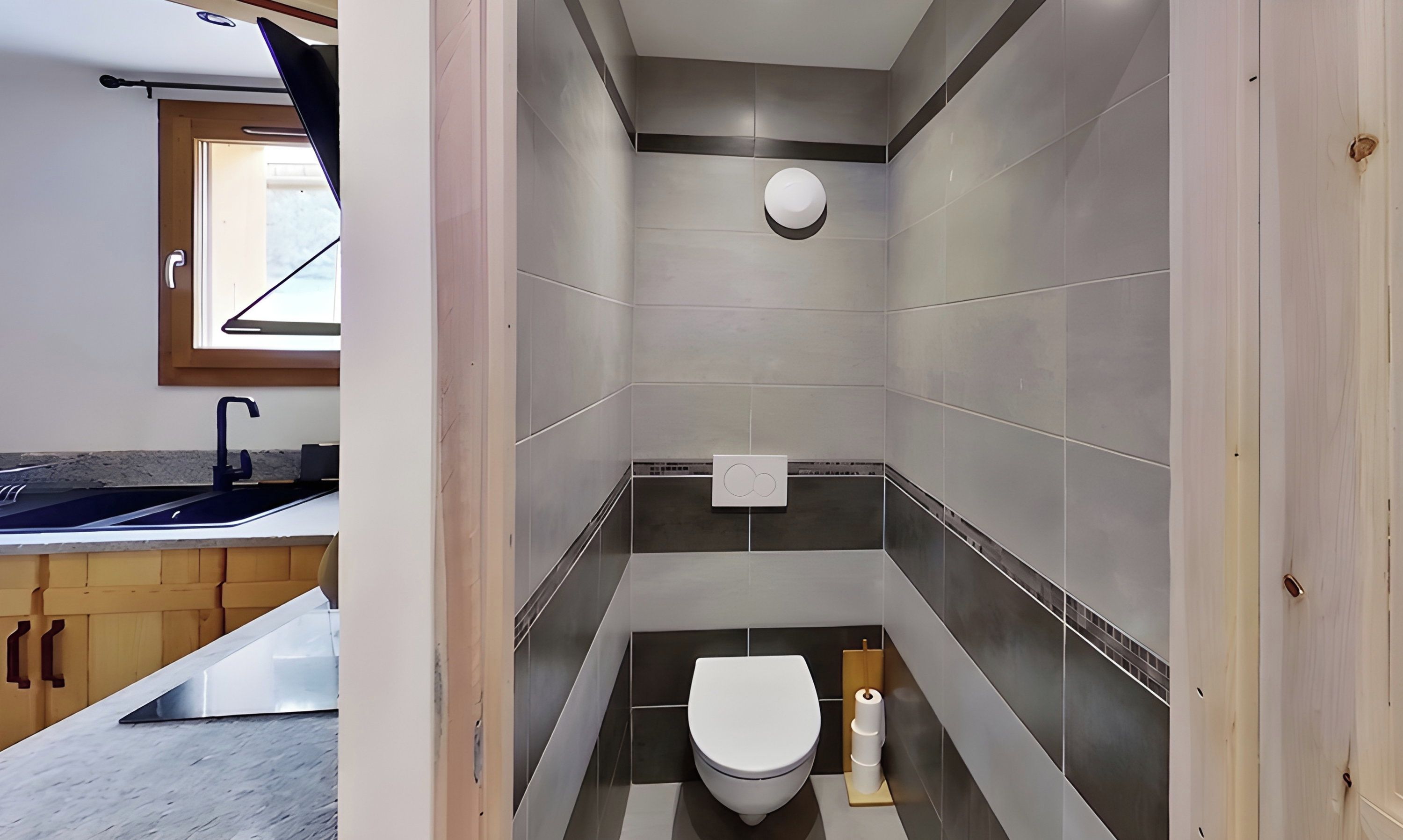 Un baño moderno con inodoro, lavamanos y ventana.