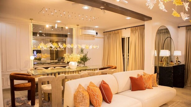 A modern living room with a white sofa, a glass coffee table, and a dining area with a chandelier. - 3 Bedroom En-Suite, Wi-Fi, Secured, 24/7 Power (Lagos)