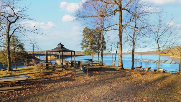 Ein Pavillon mit Blick auf einen See und eine Brücke im Hintergrund.
