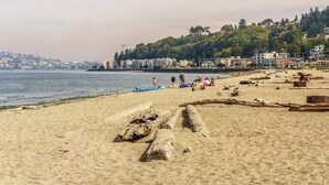 Una playa con arena, rocas y algunas personas.