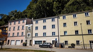 A row of multi-story residential buildings with a parking garage and a street. - 24-7 Apartment Passau - Ferienwohnung (Passau)