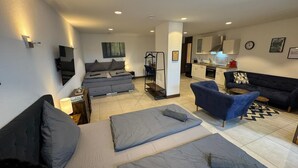 A modern apartment with a living area, a kitchen, and a bedroom. - 24-7 Apartment Passau - Ferienwohnung (Passau)