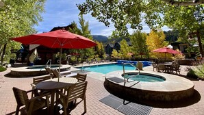 A pool area with a hot tub, lounge chairs, and umbrellas. - Upscale ski-in ski-out residence, Walk to Village & Gondola, Hot tub Access (Keystone)