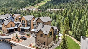 A modern residential area with multiple houses, a driveway, and a forested backdrop. - Upscale ski-in ski-out residence, Walk to Village & Gondola, Hot tub Access (Keystone)